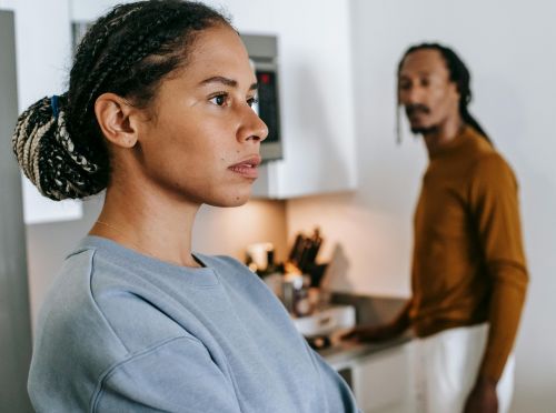 A serious young couple having a discussion in a modern kitchen setting, focusing on communication and emotions.