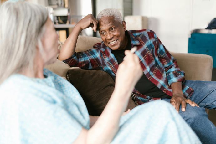 Senior couple enjoying a happy and relaxed conversation on a cozy sofa.