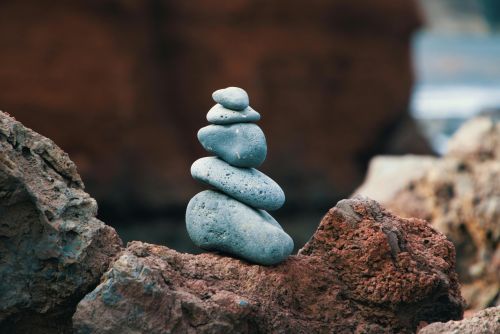 Peaceful arrangement of balanced stones in an outdoor rocky setting, symbolizing harmony.