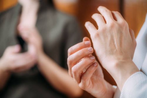 Two individuals practicing EFT tapping therapy. EFT tapping hands.