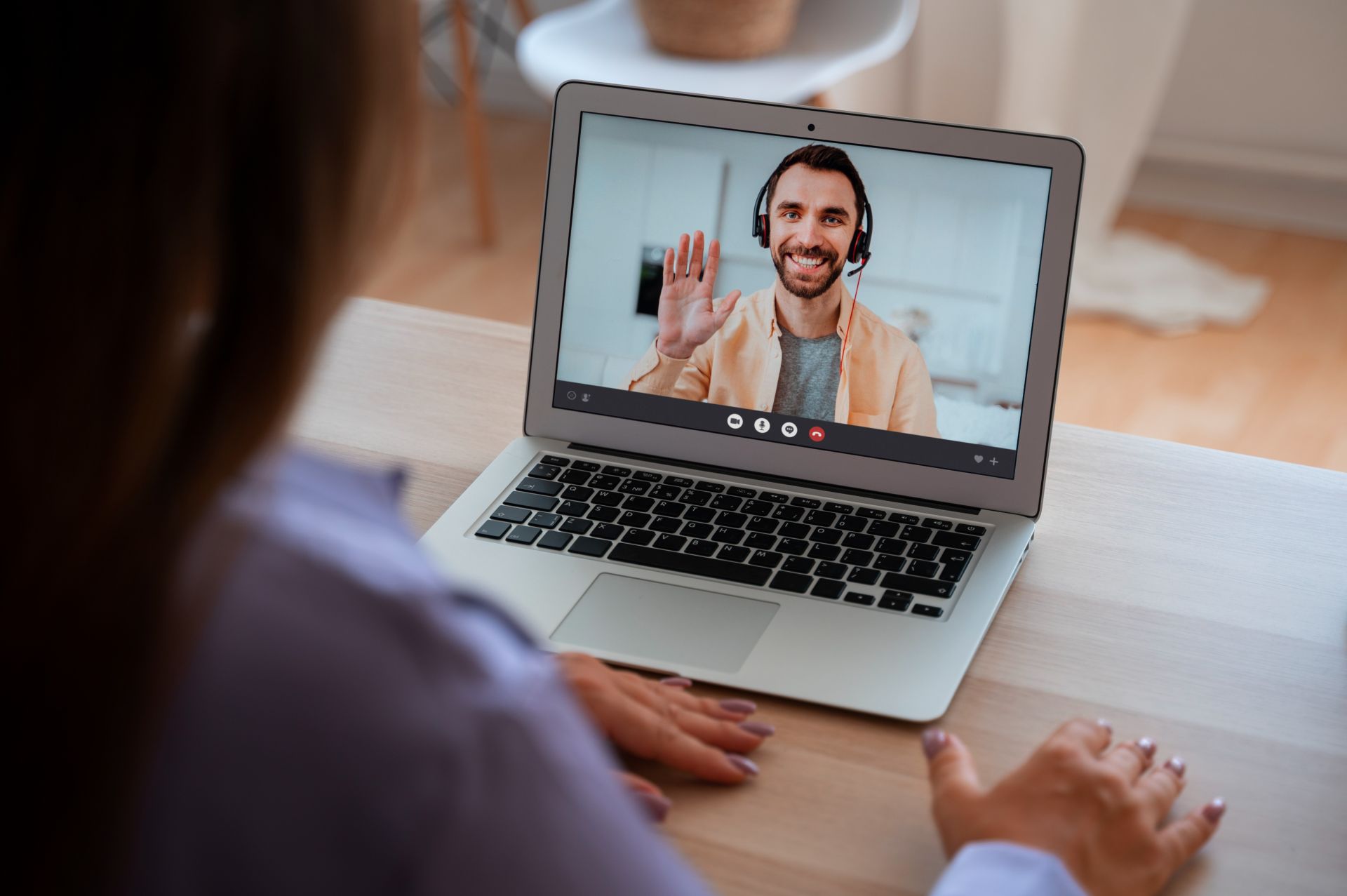 Smiling woman in eyeglasses using a laptop at home office with decor and November calendar.